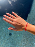 Red Ribbon Manifestation Bracelet worn on wrist